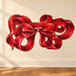 Red Christmas ribbon bow sticker with thick swirled loops and center knot