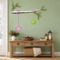 Christmas tree branch wall decal with green needles, pink star, and hanging ornaments