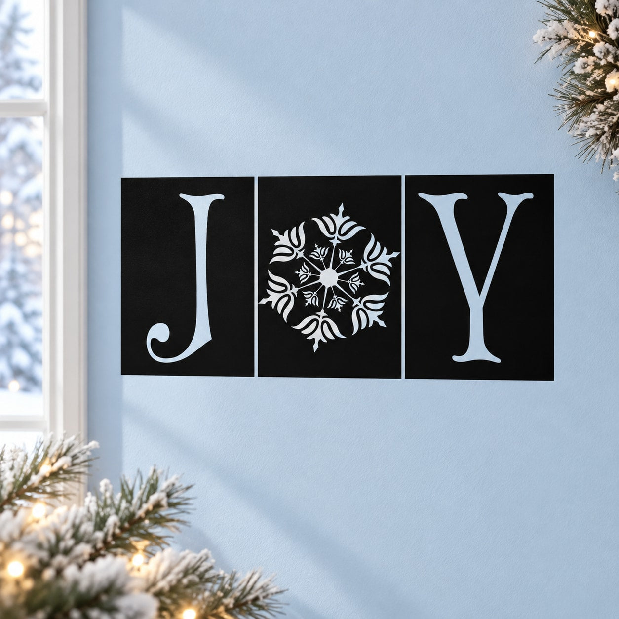 Three black square holiday tiles with white J, snowflake, and Y decals