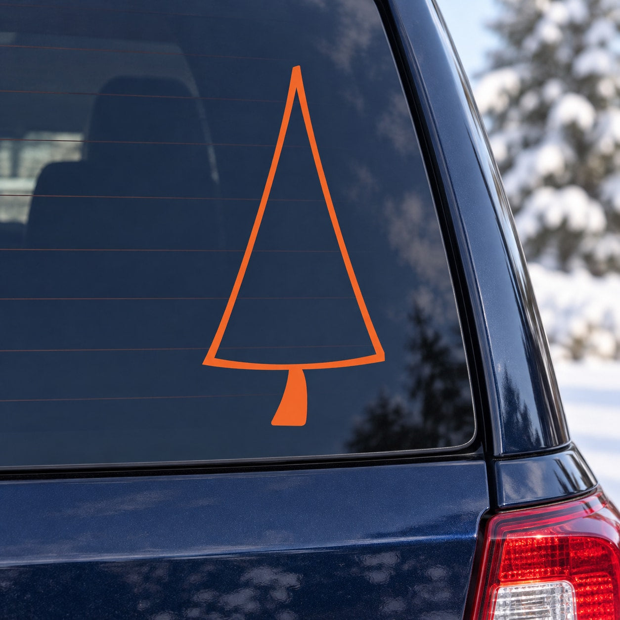 Orange triangle Christmas tree decal on dark car window glass