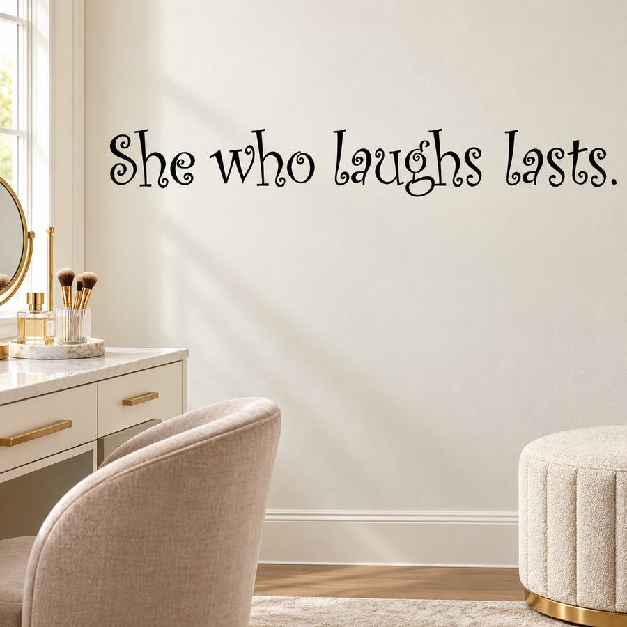 Wall decal with cursive quote "She who laughs lasts"