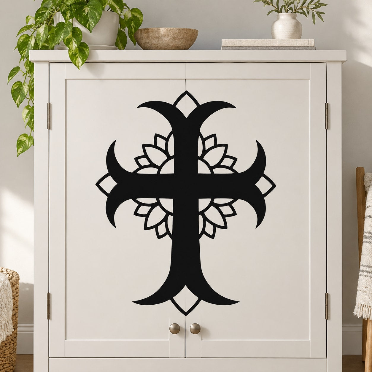 Black cross decal with layered flower petals, centered on a white cabinet door