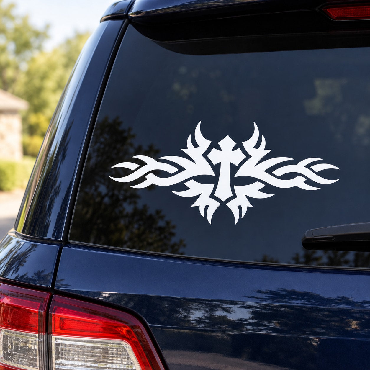 Cross-shaped tribal fire decal on dark car rear window