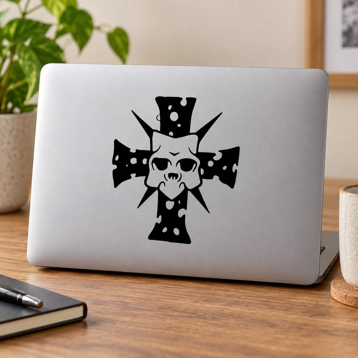 Light gray laptop with black demon mask cross decal