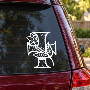 Car decal with white cross and flower motif on a dark window