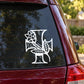 Car decal with white cross and flower motif on a dark window