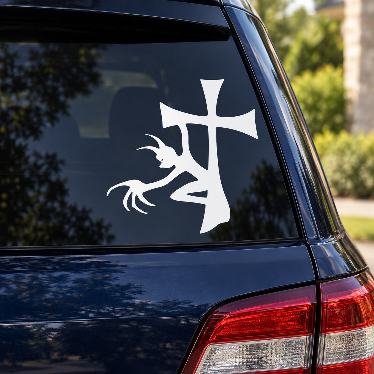 White cross decal with demon figure on car window