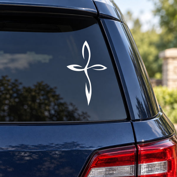 White delicate cross decal with flowing curved lines on a car window panel