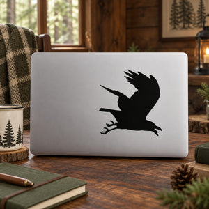 Flying raven silhouette decal, black bird in mid-flight on light surface