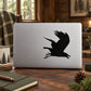 Flying raven silhouette decal, black bird in mid-flight on light surface
