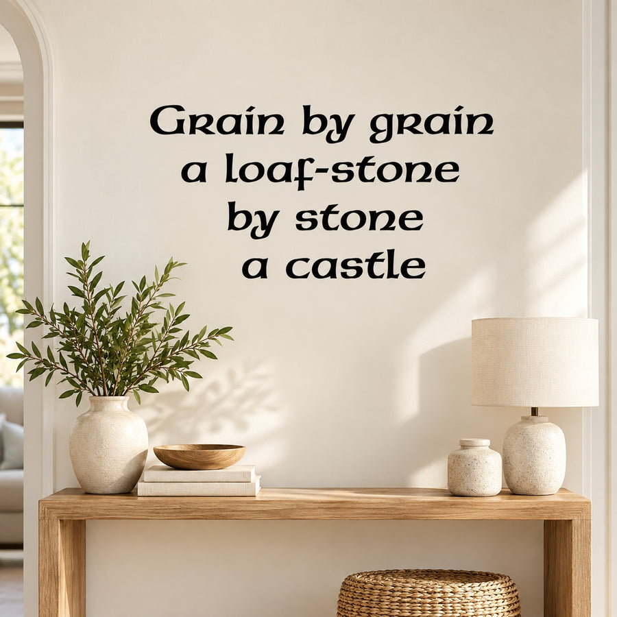 Wall decal with black quote lettering: Grain by grain a loaf-stone by stone a castle