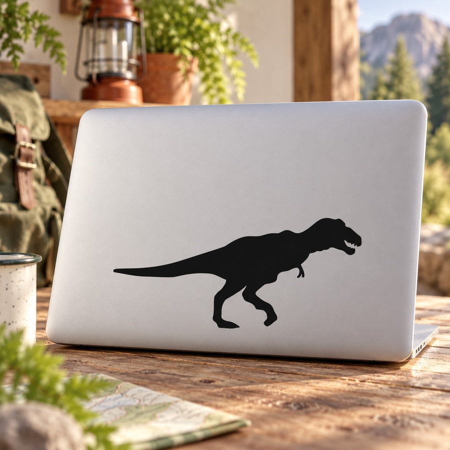 Walking Tyrannosaurus Rex decal in black, shown on a light laptop lid