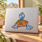 Orange and blue illustrated archelon animal sticker on a light laptop surface