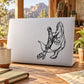 Attacking dinosaur decal with black line-art on white laptop lid