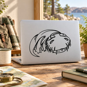 Swimming dinosaur decal sticker in black line art on a white laptop