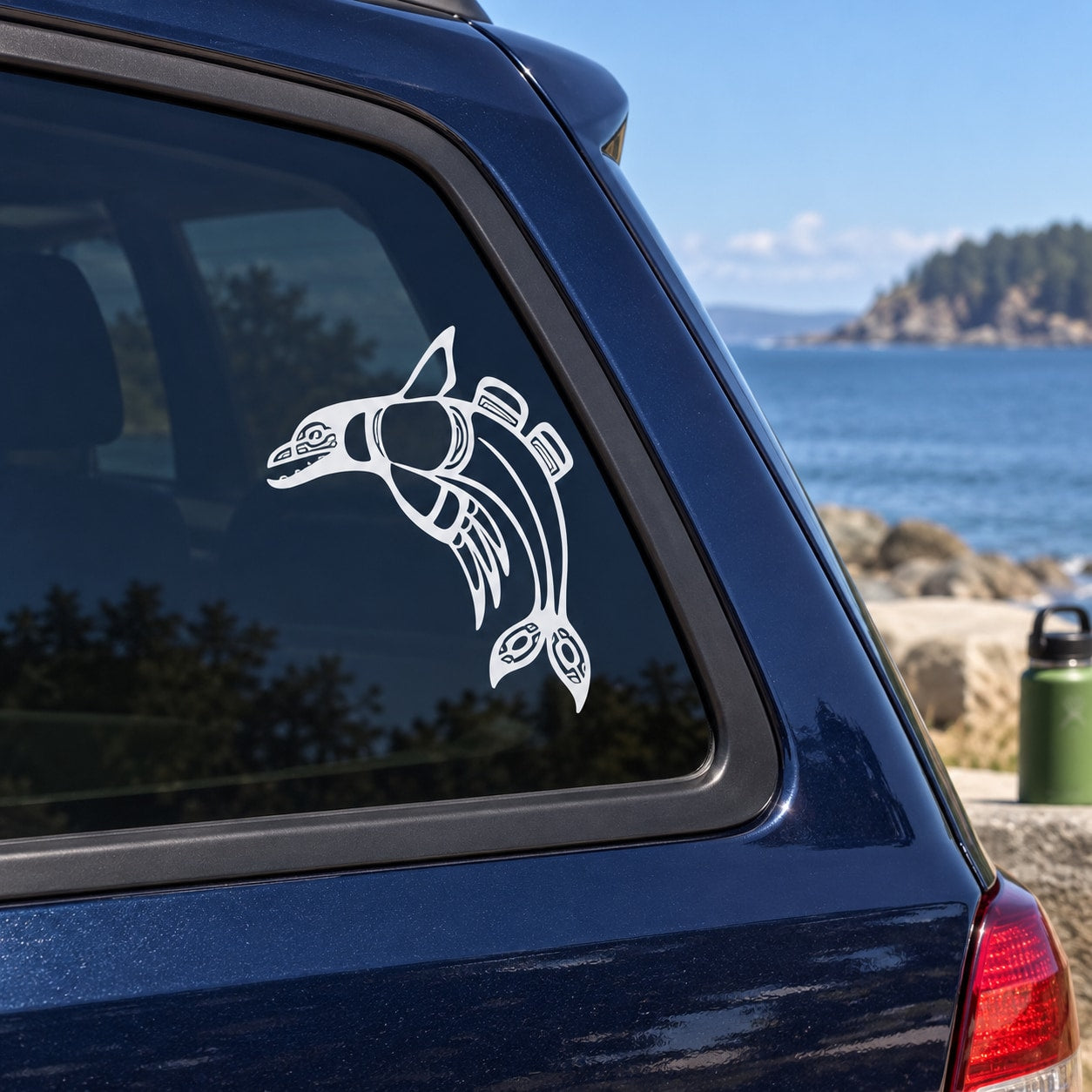 Alaskan Native dolphin window decal, white graphic on dark blue car glass