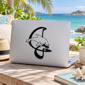 Black dolphin letter decal on a laptop lid