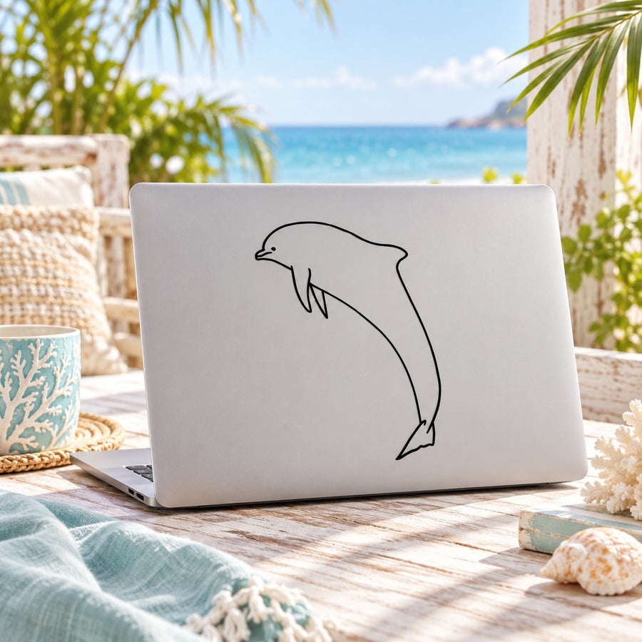 Dolphin line-art decal sticker on a light-colored laptop cover
