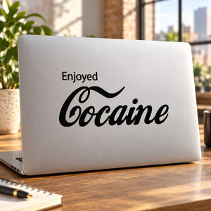 Black 'Enjoyed Cocaine' decal on light laptop lid