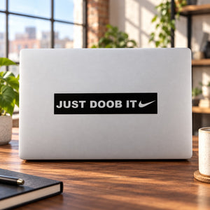 Laptop decal with black "JUST DOOB IT" text and swoosh mark, sticker centered