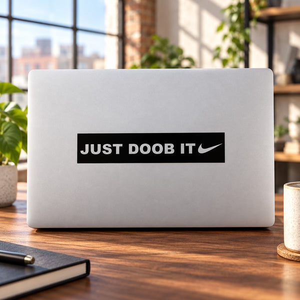 Laptop decal with black "JUST DOOB IT" text and swoosh mark, sticker centered