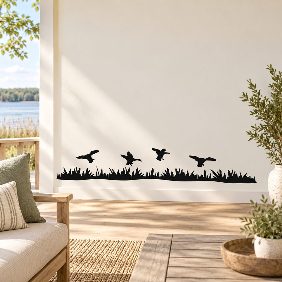 Wall decal of five flying ducks above dark grass silhouette