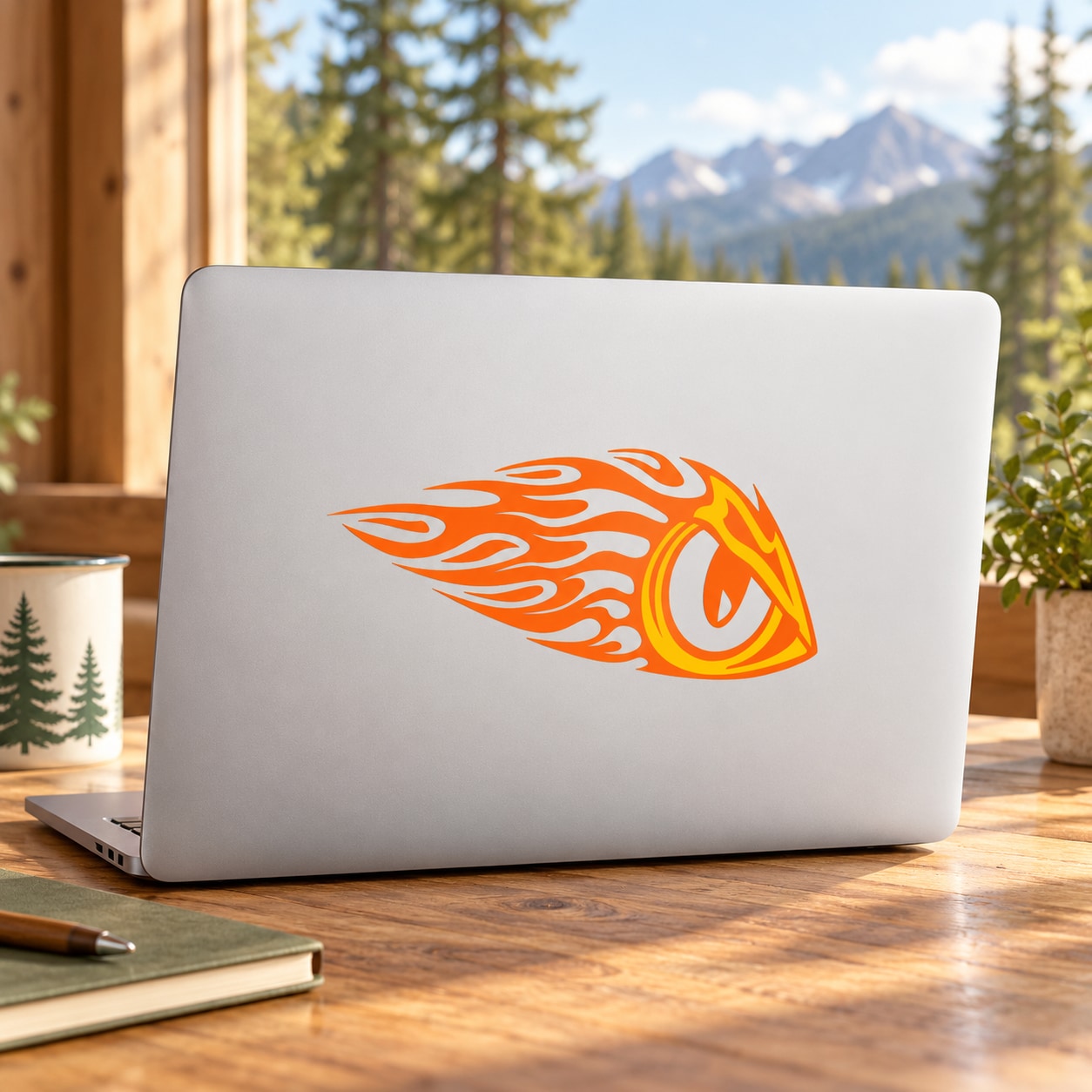 Orange eagle-eye graphic sticker on a light laptop lid