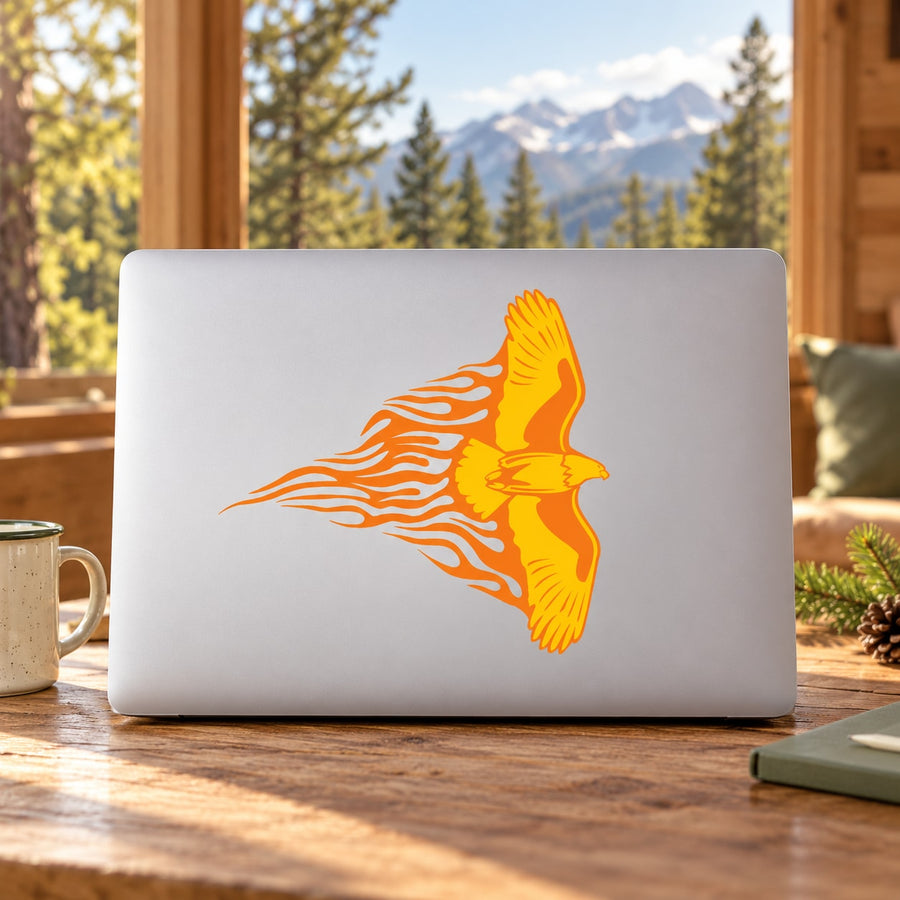 Orange flying eagle decal with flame-like wings on a laptop
