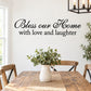 Wall decal with cursive 'Bless our Home with love and laughter' text, black