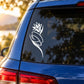 White outlined flower decal on dark car window, leaf and petal swirl outline