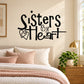 Wall decal reading “Sisters by heart” with heart icons