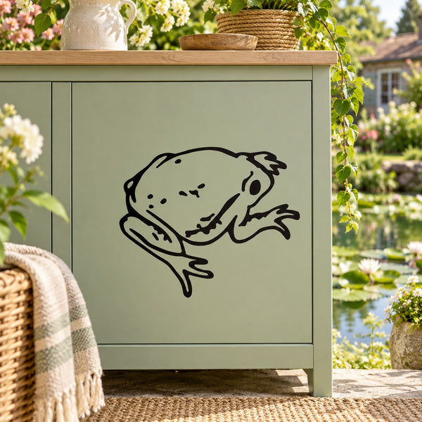 Young toad decal with black outlined toad face on light surface