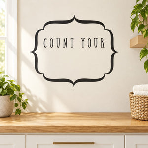 Black wall decal with ornate frame and 'COUNT YOUR' lettering