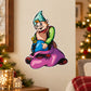 Cartoon elf sticker: green hat elf sitting with purple sack and blue belt