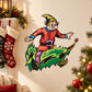 Elf riding tree cartoon sticker with red outfit, green leaves, and black boots