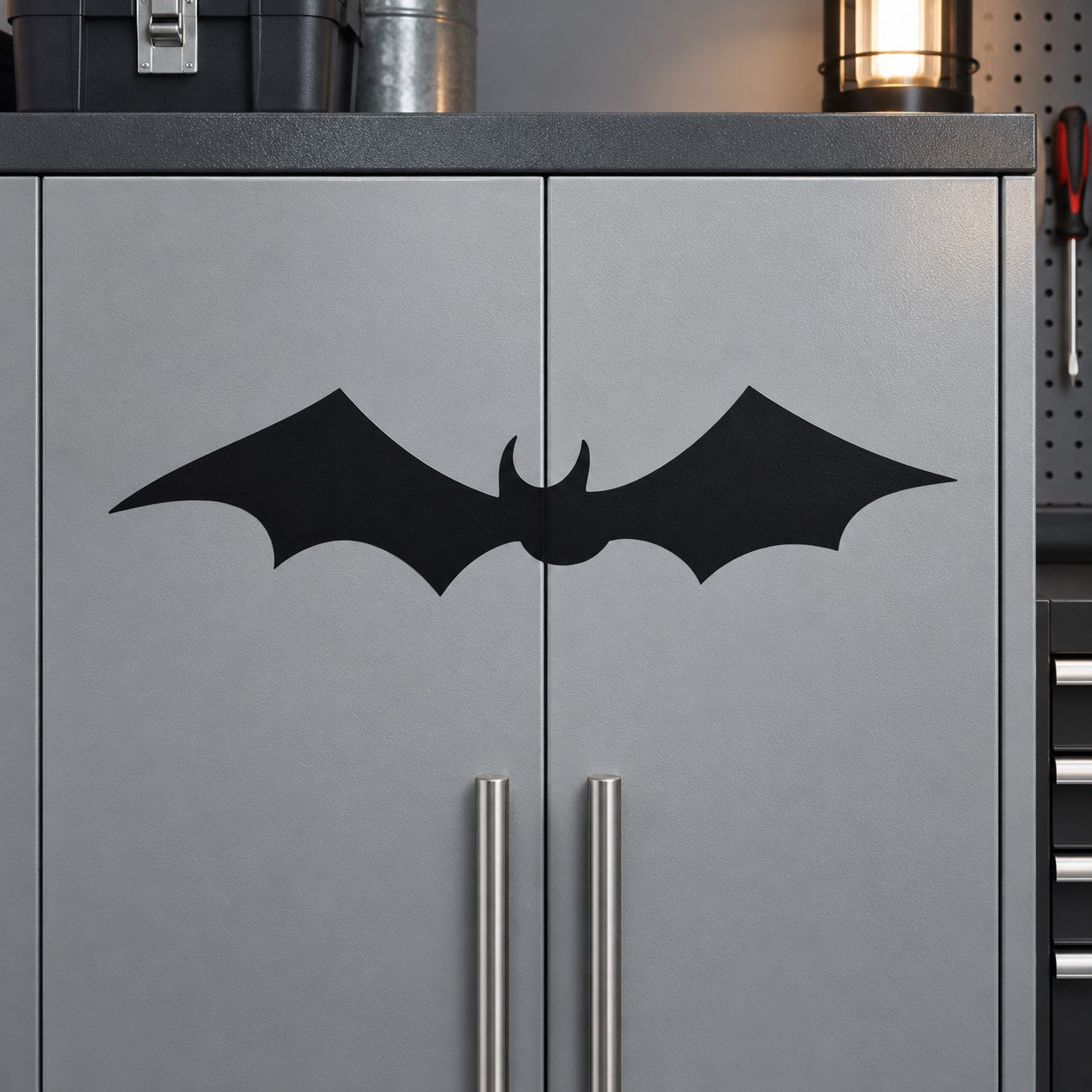 Black bat wall decal with symmetrical wings on gray cabinet door