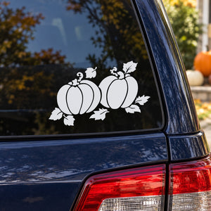 Set of two white pumpkin decals with leaves and vines on a car window