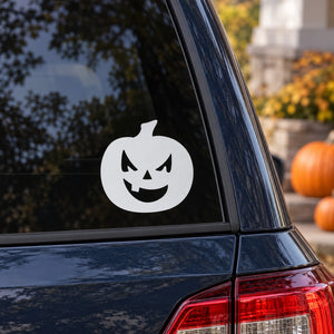 Halloween jack-o-lantern decal with single tooth, white face on a dark window