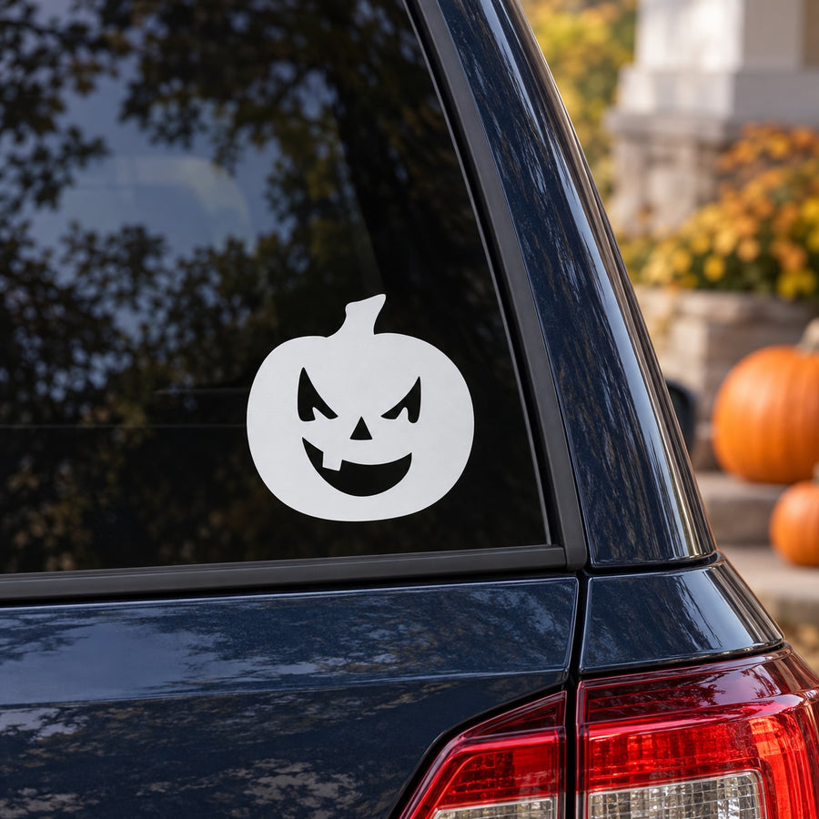 Halloween jack-o-lantern decal with single tooth, white face on a dark window