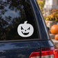 Halloween jack-o-lantern decal with single tooth, white face on a dark window