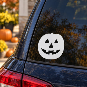 White jack-o-lantern face decal on car rear window glass, circular sticker