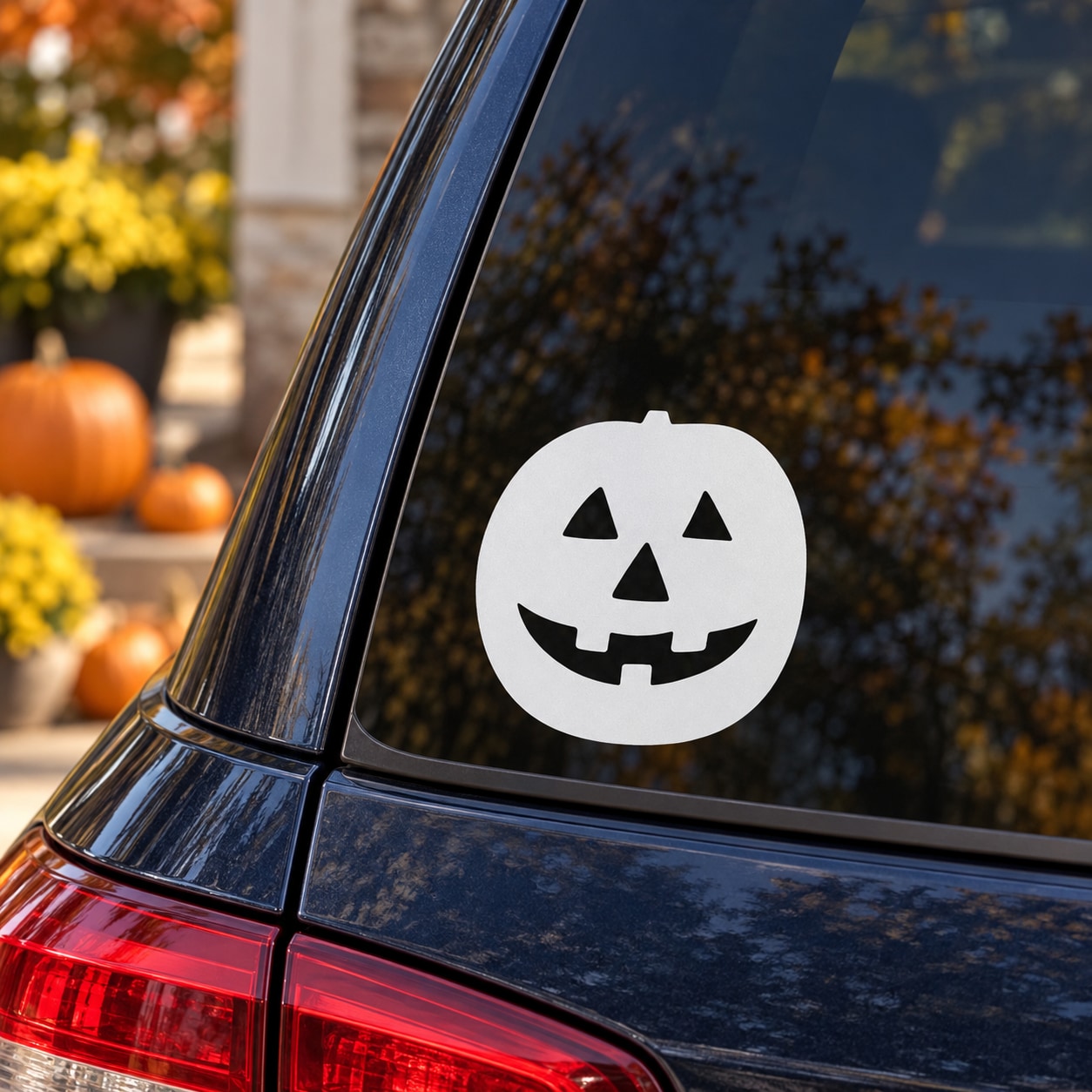 White jack-o-lantern face decal on car rear window glass, circular sticker