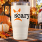 White tumbler with orange pumpkin face and black “scary” text decal