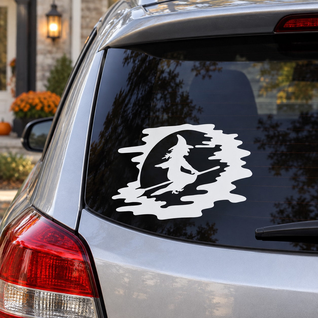 White riding witch decal on dark car rear window glass