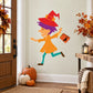Halloween witch trick-or-treating sticker: cartoon girl in red hat holding candy bag.