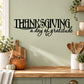 Thanksgiving wall decal with black lettering 'Thanksgiving' and script 'a day of gratitude'