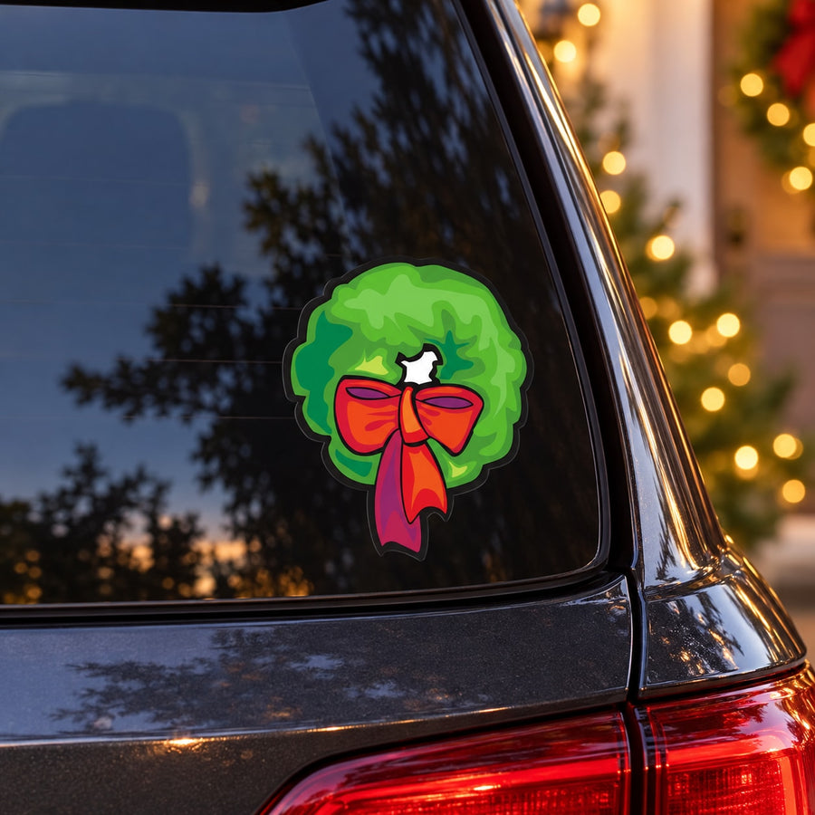 Green wreath sticker with red bow and white center for car window