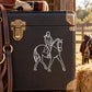 Equestrian rider and walking horse line art decal in white on dark surface