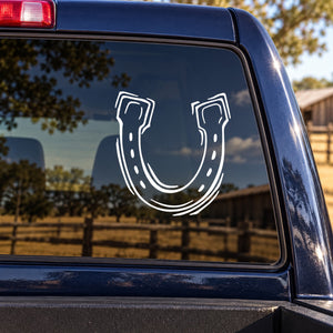 White horseshoe decal with outlined curved shape and small dots, on a car window