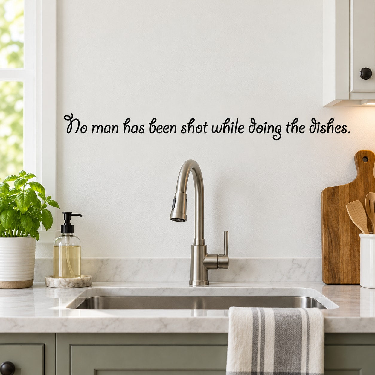 Wall decal with black cursive quote: 'No man has been shot while doing the dishes'.